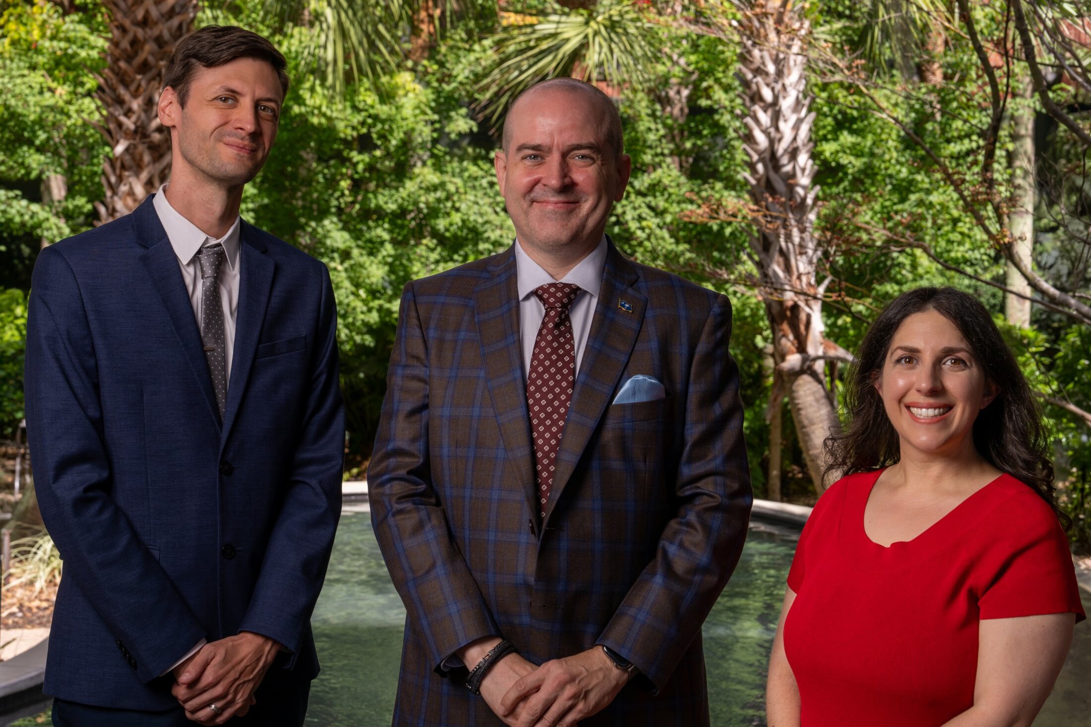 Three tobacco use researchers pose together in a garden setting.
