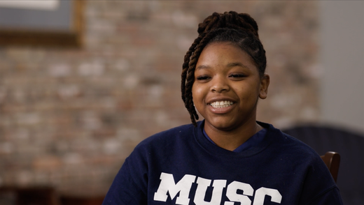 close up of a woman in a navy sweatshirt smiling at the camera