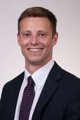 Aaron Miller wearing a dark blue sport coat with a blue and red tie