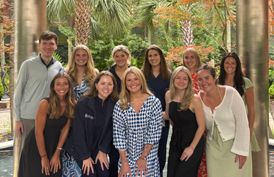 A group of people pose together outside in a group portrait.