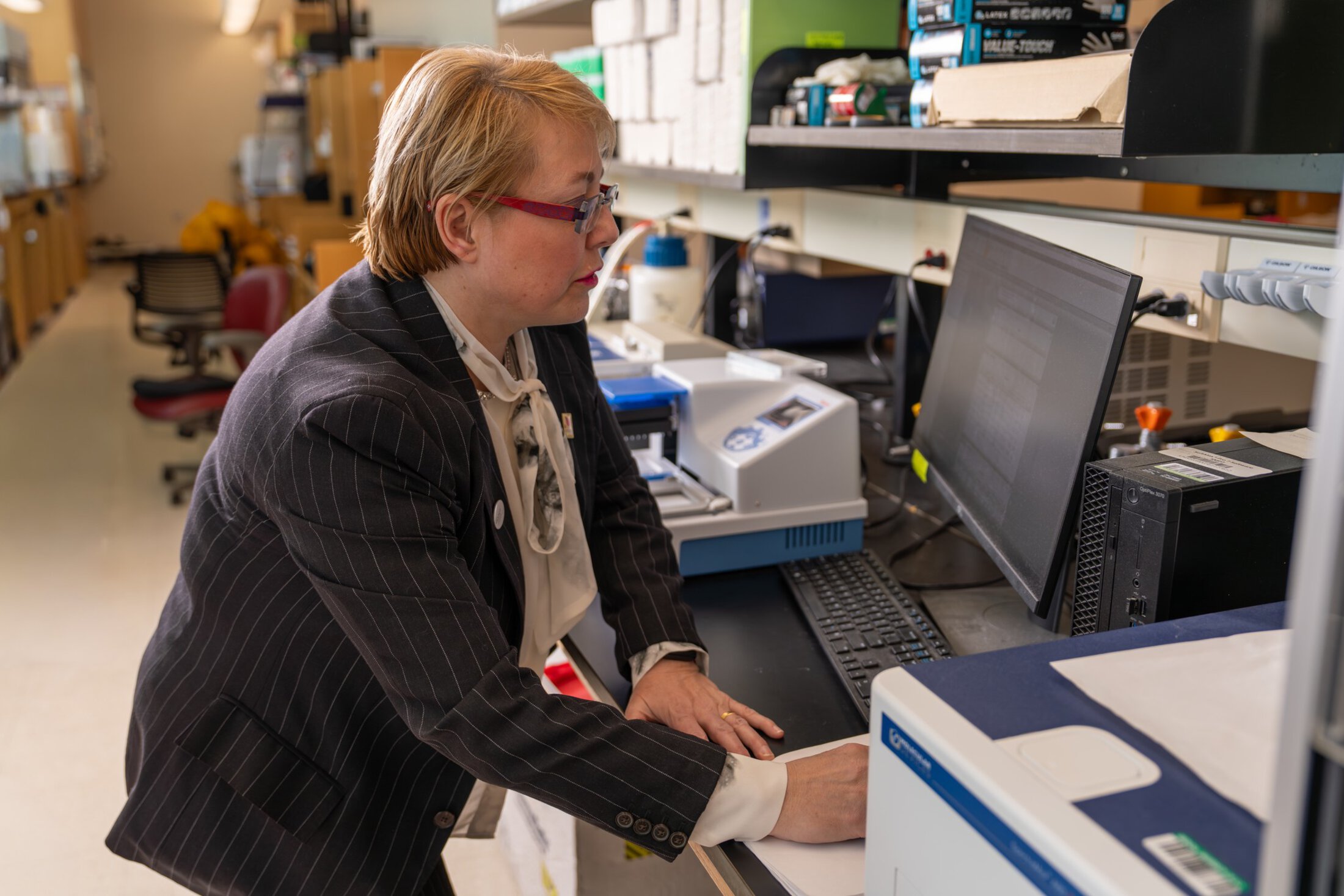 a researcher leans over to look at her computer in the lab