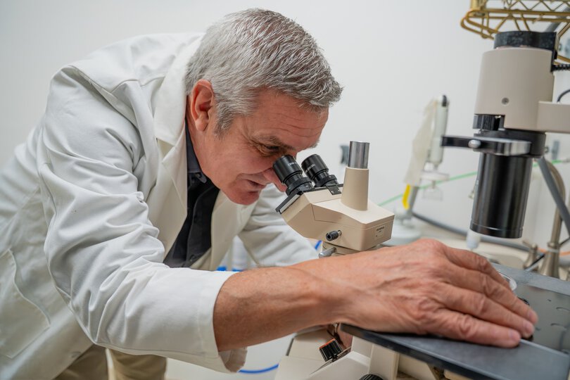 Philip Howe wearing a white coat in lab