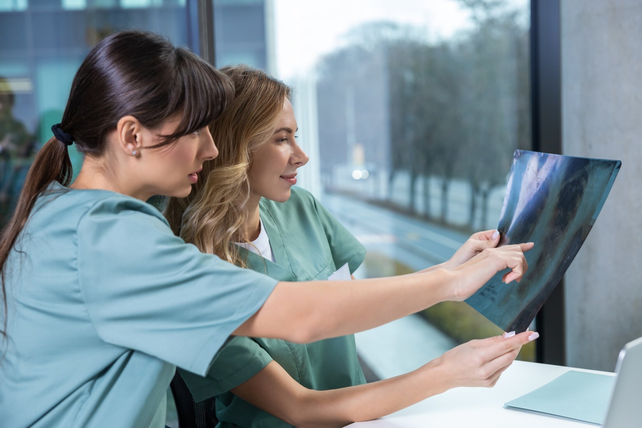 Young competent female doctors looking at X-ray