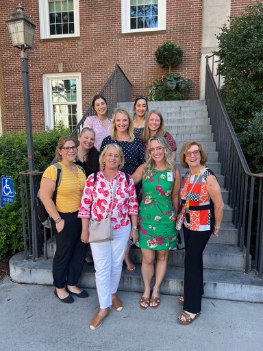 A group of women stand on the steps together.