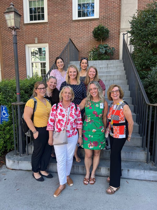 A group of women stand on the steps together.