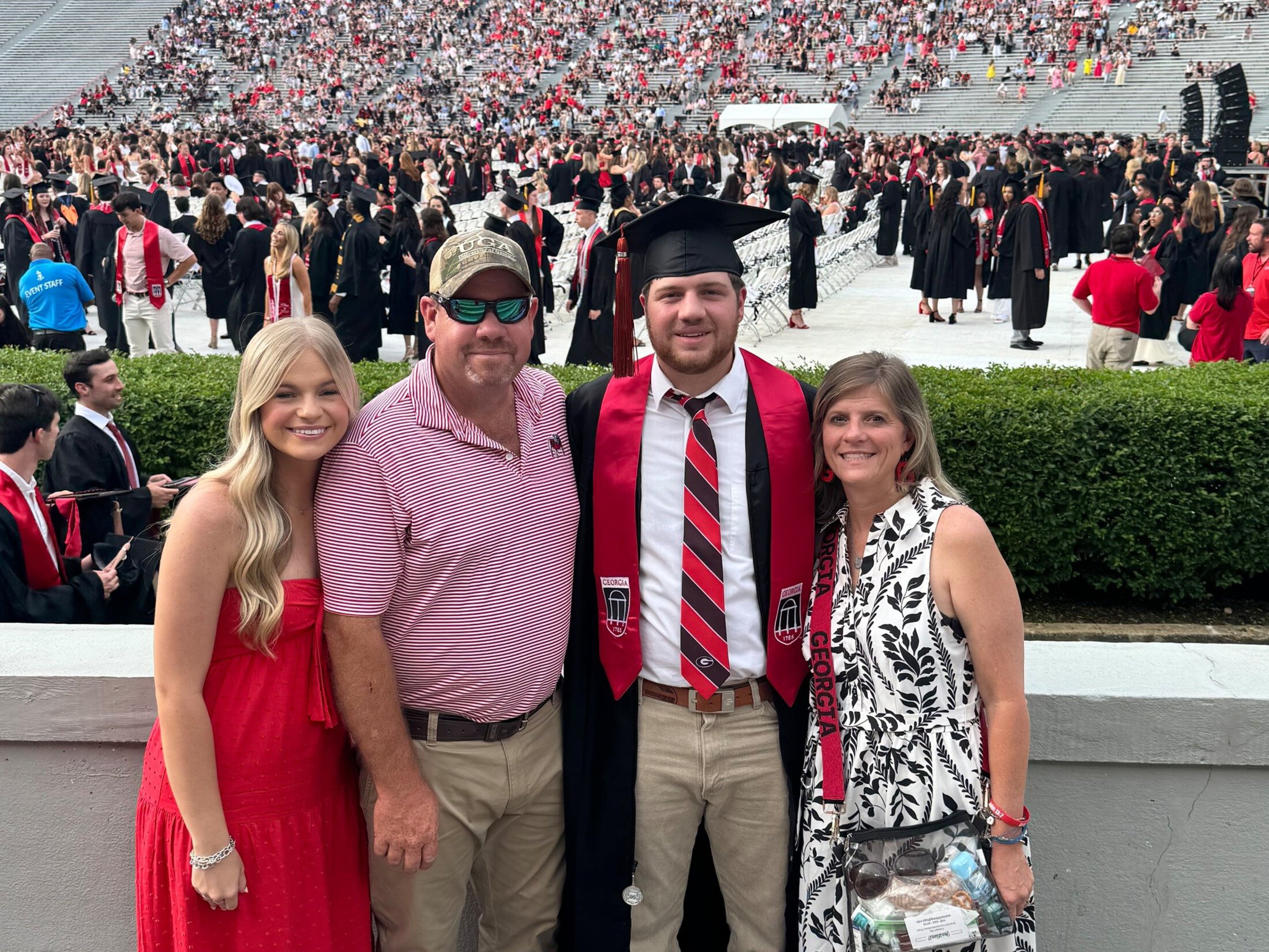 a family decked in pops of Georgia red poses with their new graduate