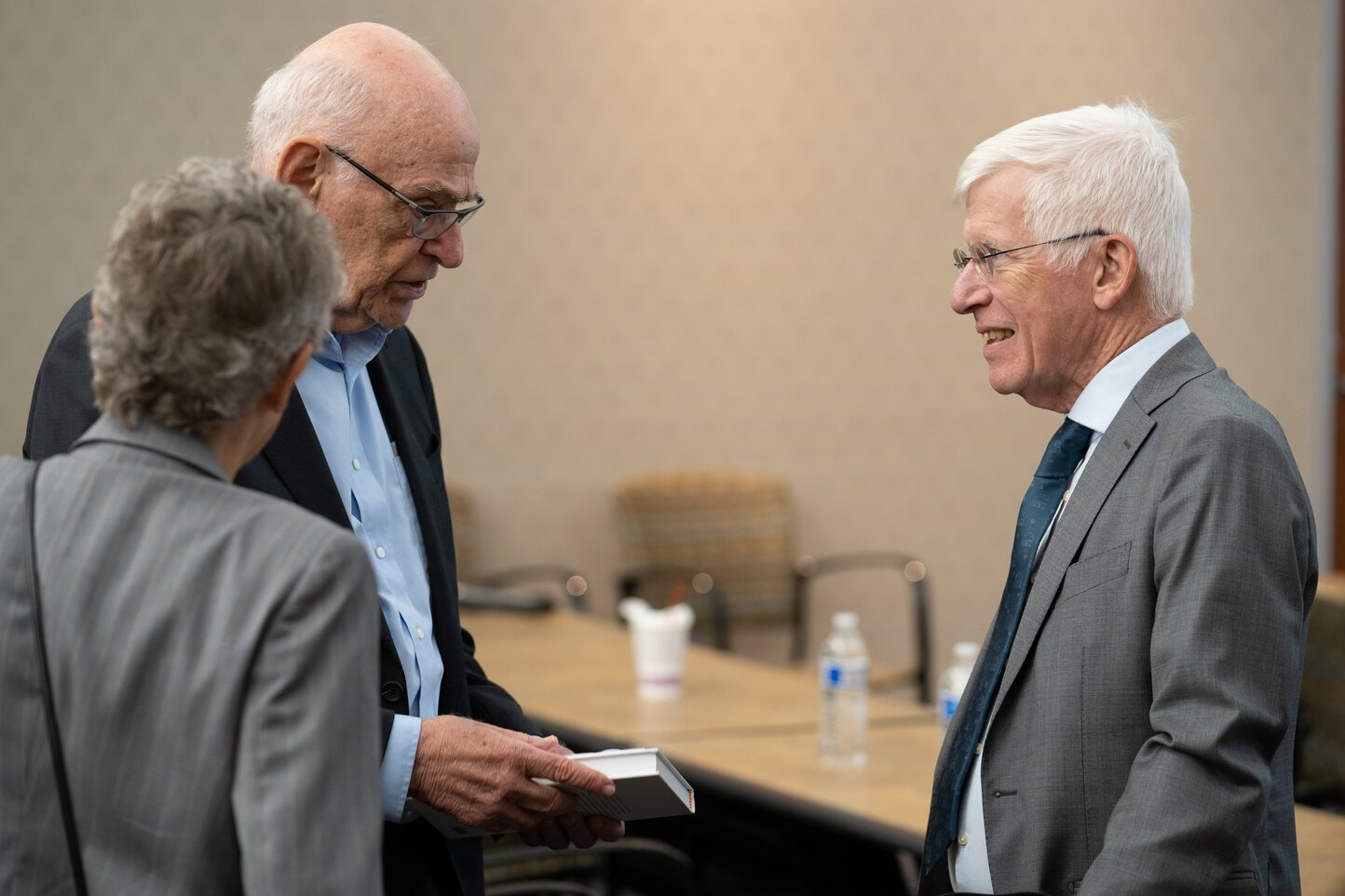 Two men chat in a conference room.