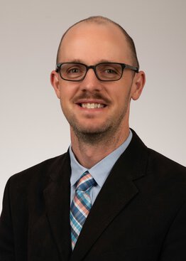 Jonathon Nye, PhD, Professor wearing a brown suit and blue shirt with tie