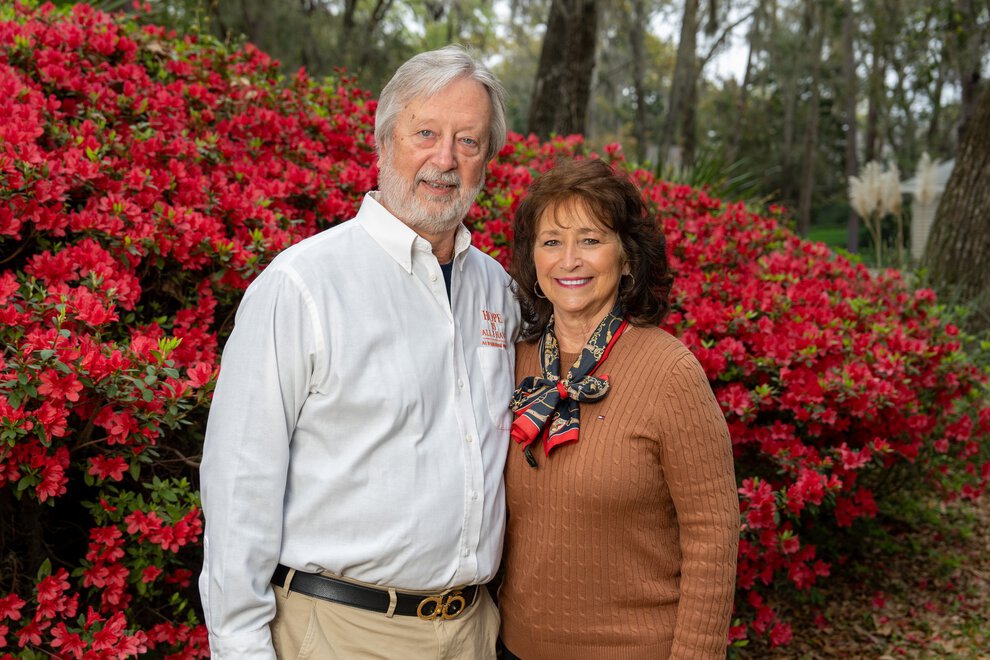 Billy and Linda Douglas pose in front of vibrant azaleas in their front yard.
