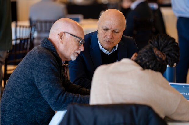 A clinician, lab researcher and population scientist huddle together over an idea.