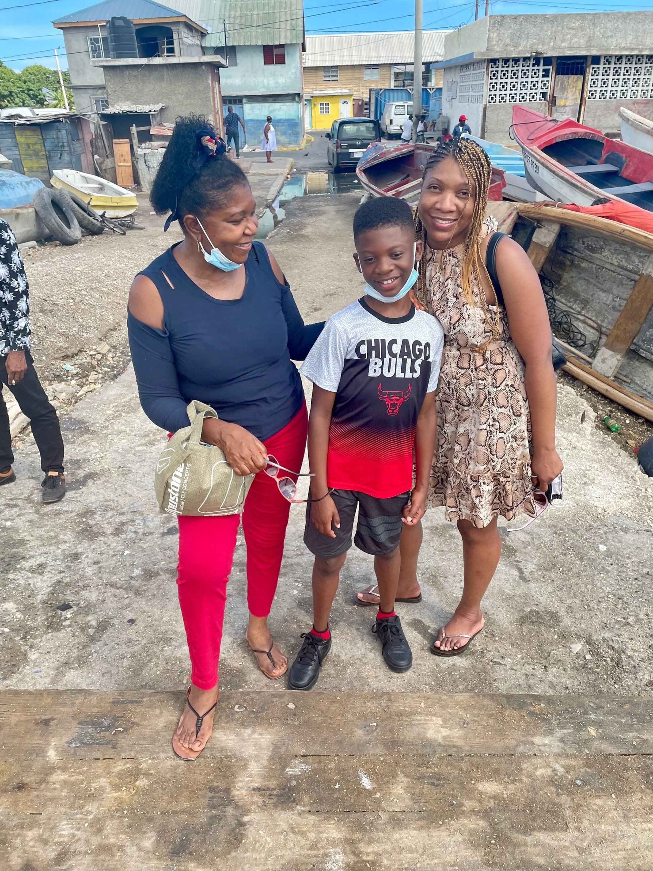 Jamaica story Fowling with family wearing Chicago Bulls basketball t shirt outside with boats in the background