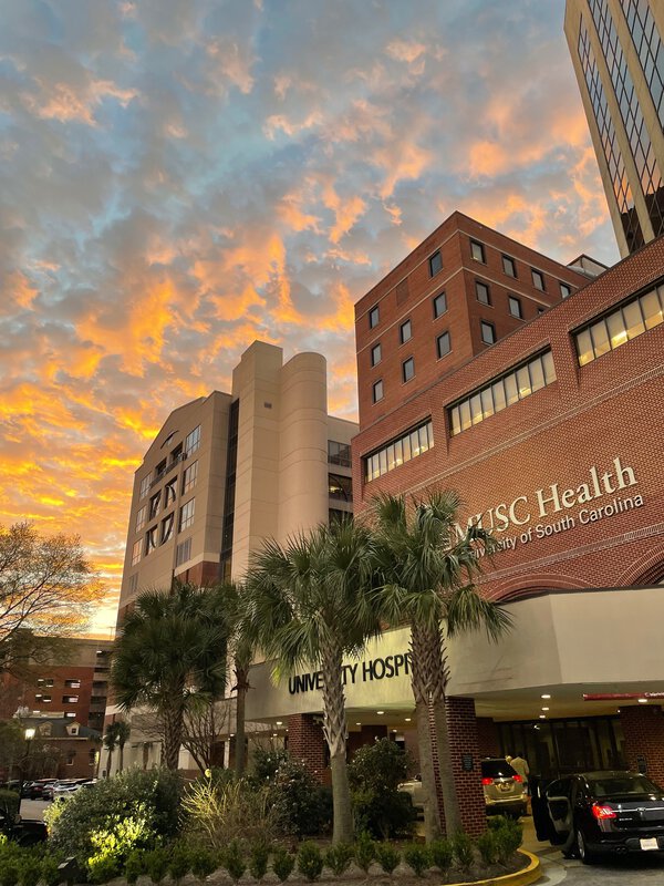 MUSC Main Hospital exterior building photo with cars under the main entrance of the hospital