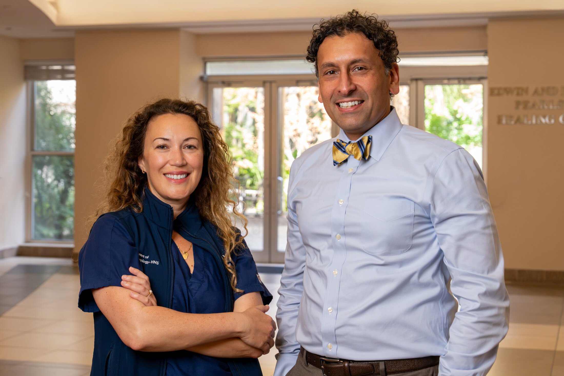 Two physicians pose together for a portrait.