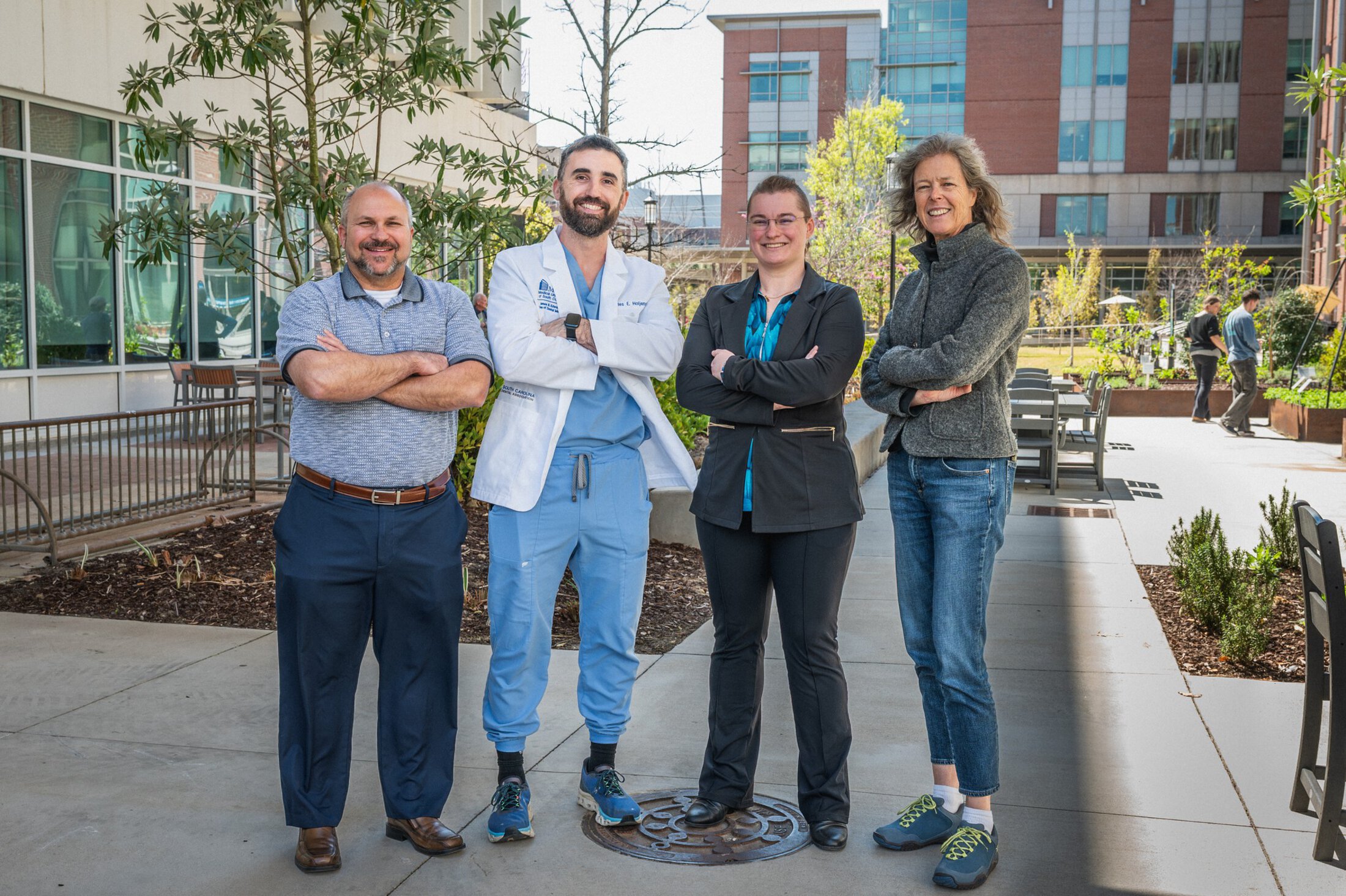 A group of people stands in the MUSC courtyard with their arms crossed.