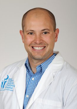 Austin Biggs, MD, Pediatric Critical Care wearing a white coat