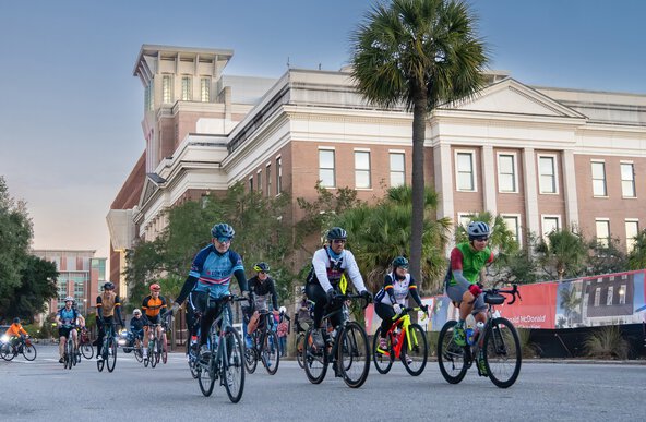 a group of Lowvelo25 cyclists rides past the MUSC Hollings Cancer Center building, which uses the money raised during the event for research