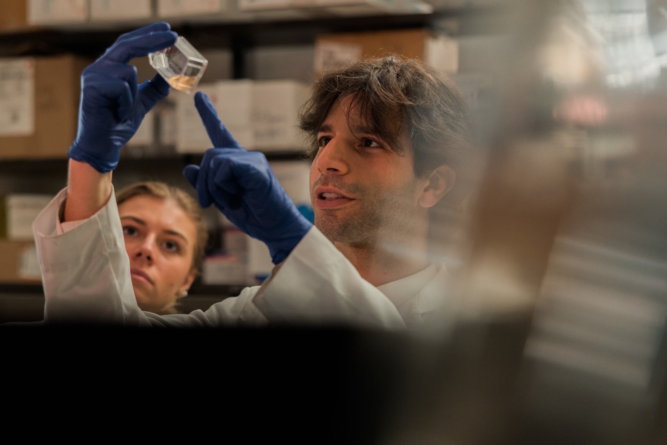 Leonardo Ferriera points to something in a sample which he and another researcher are inspecting.