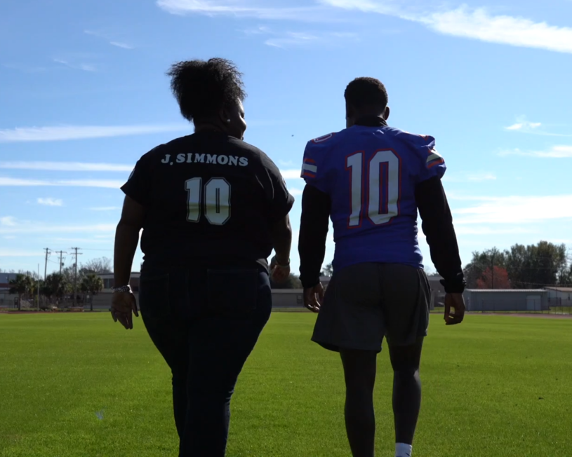 people walking on a football field wearing football jersey