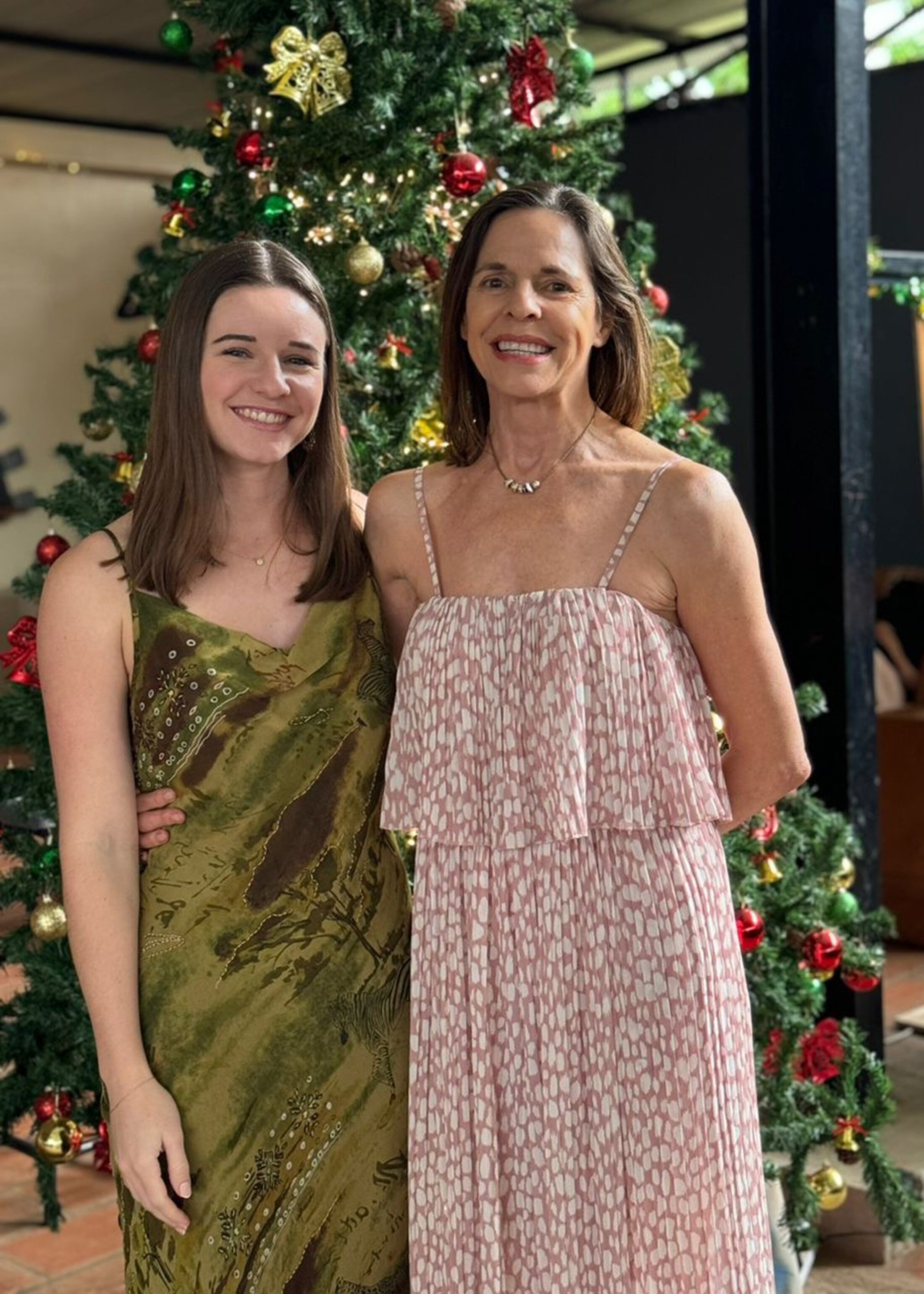 a mother and daughter in front of a Christmas tree