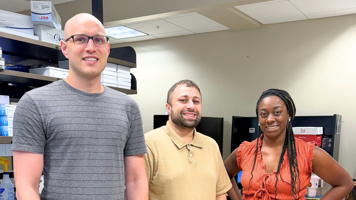 Researchers Stephen Walterhouse, Khalil Mallah, Ph.D., and Tialeisha Corley stand together in the Mallah Lab.