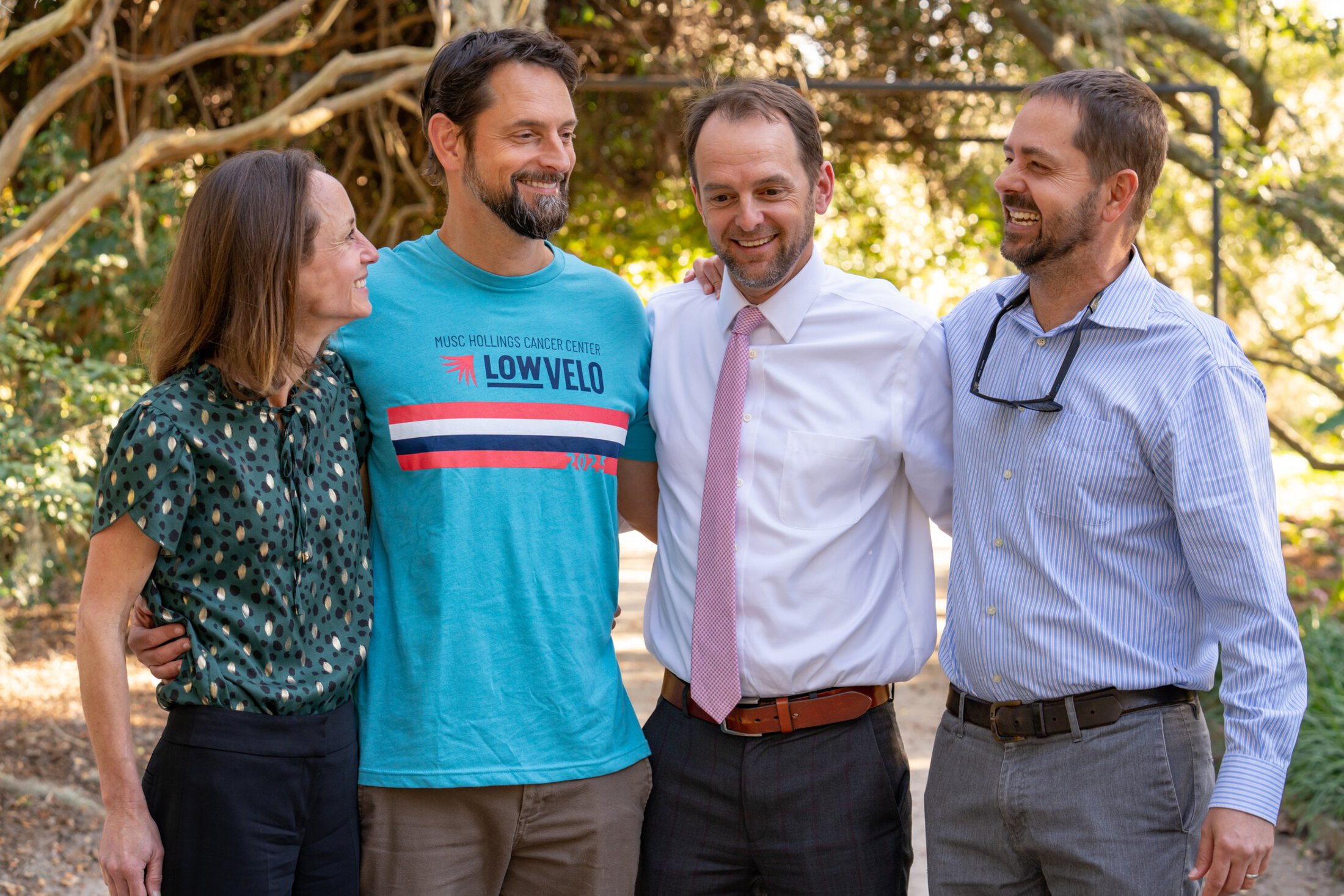 Four adult siblings laugh together.