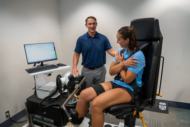 Man and woman in research lab. Woman sitting, man standing, looking at monitor