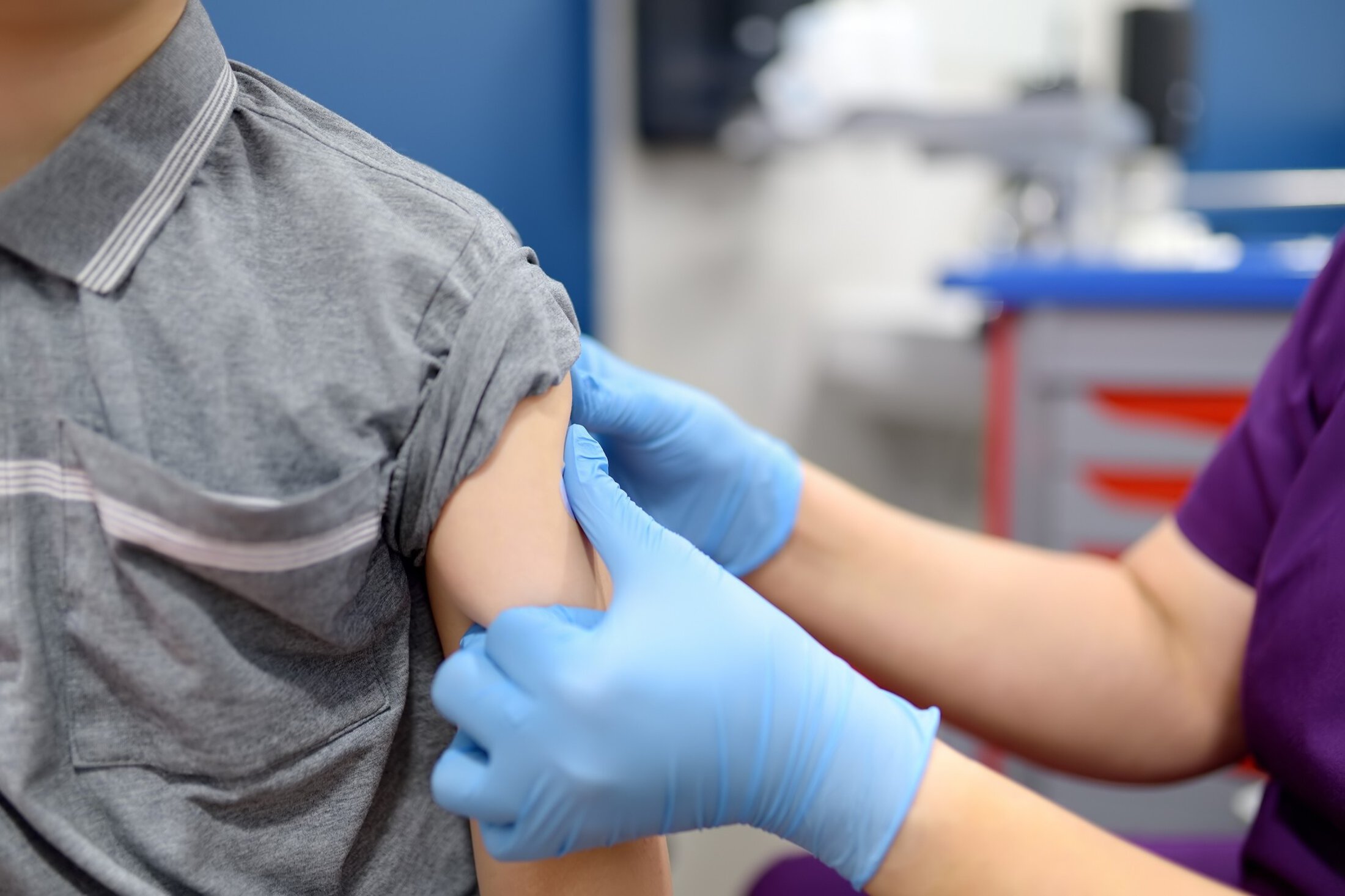 A boy is being vaccinated. A child is given a vaccine during an epidemic or outbreak of a disease. A kid during routine vaccination