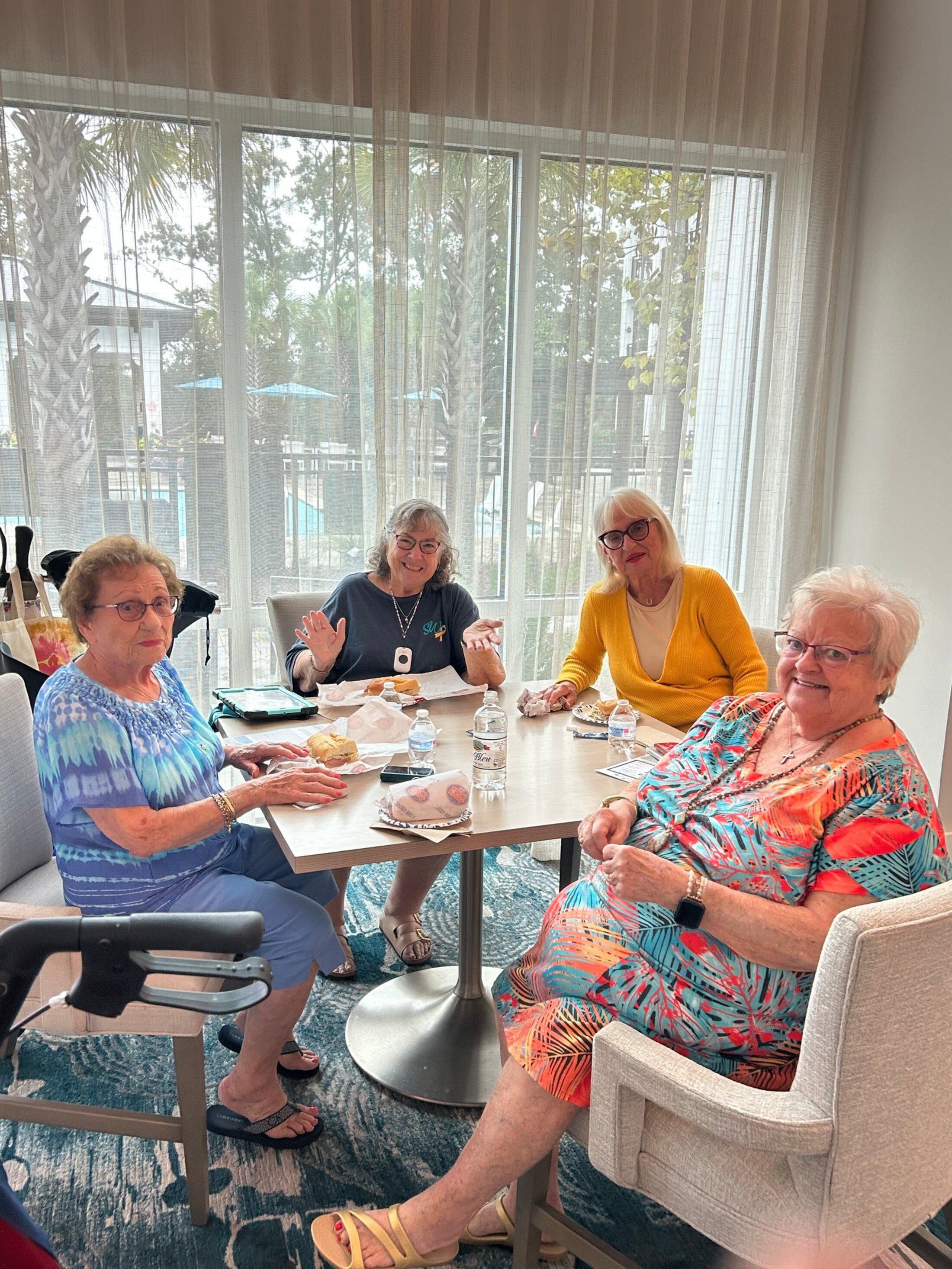 Four older women sharing a meal.
