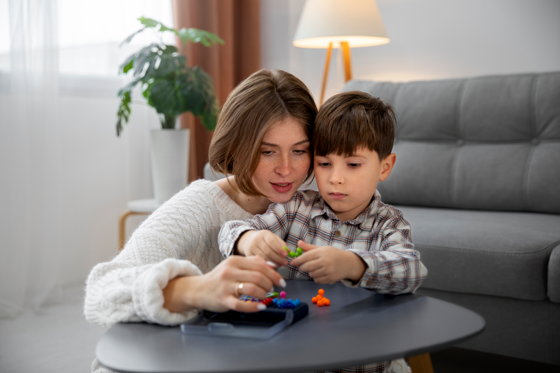 Mother and son playing with blocks on the floor.