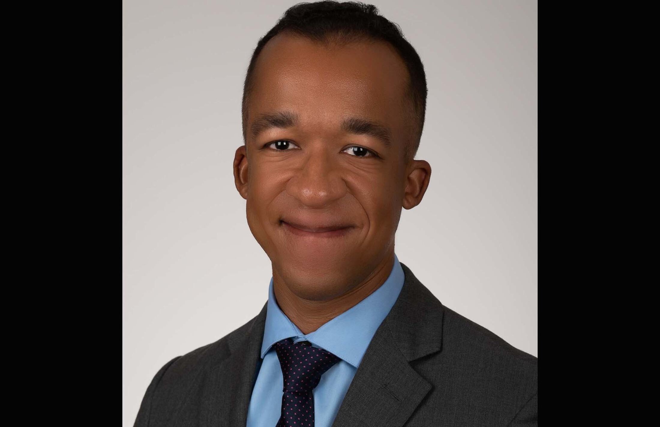 Headshot of a man wearing a suit and tie.