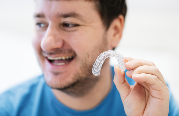 Man holding his retainer out for Orthodontics
