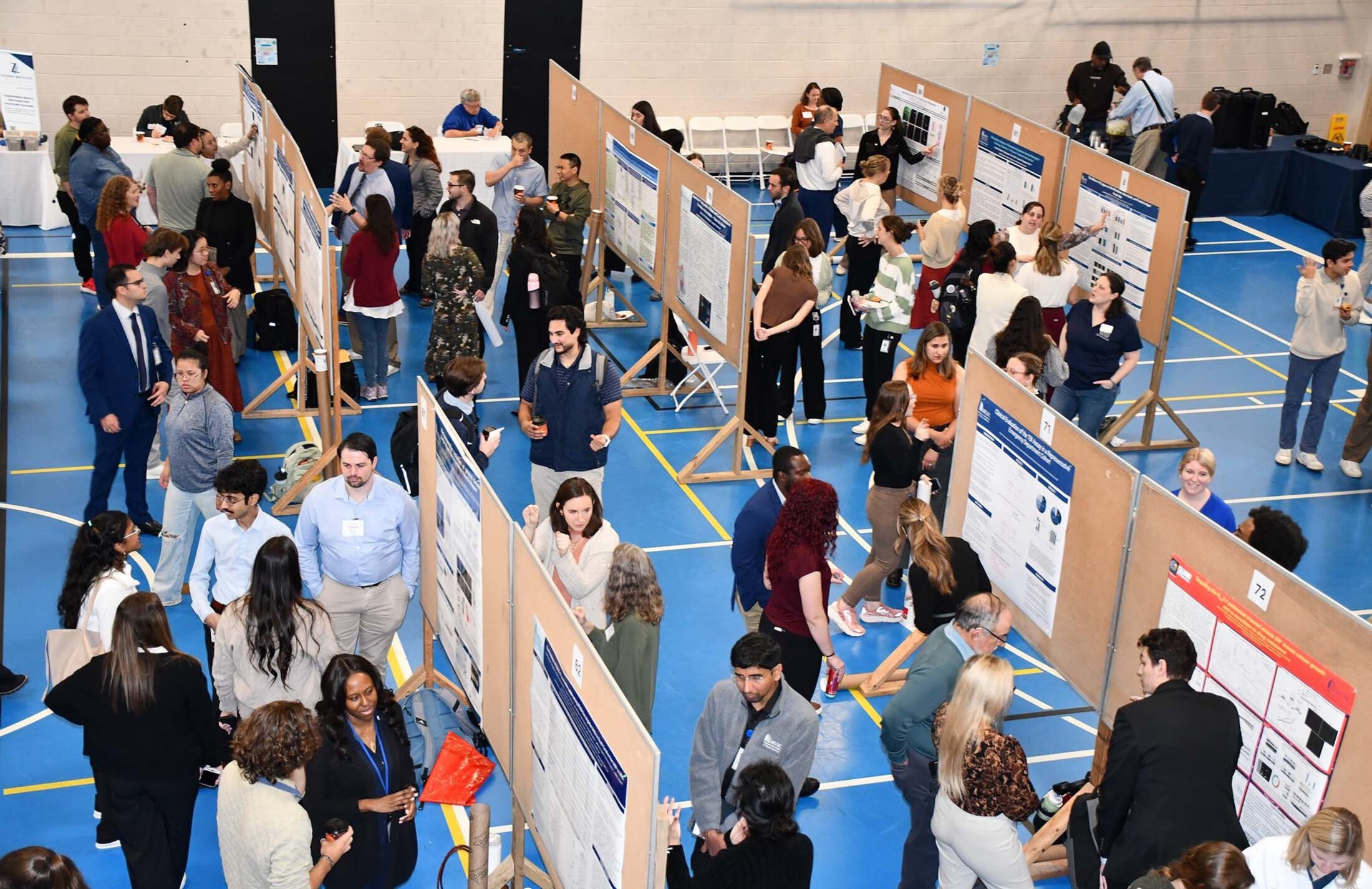 Lines of posters with people gathered around them.