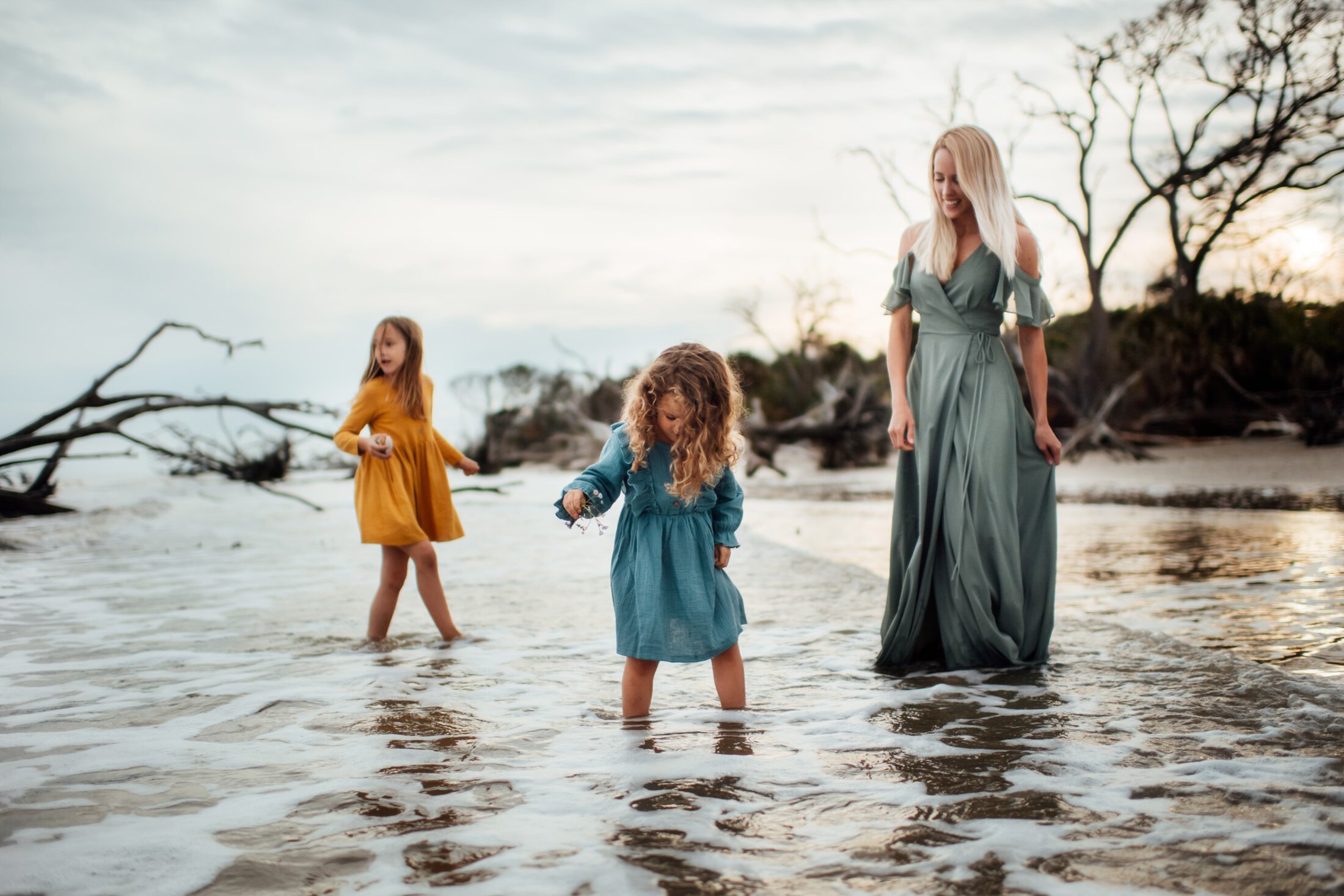 Mother standing int the ocean with her two children.