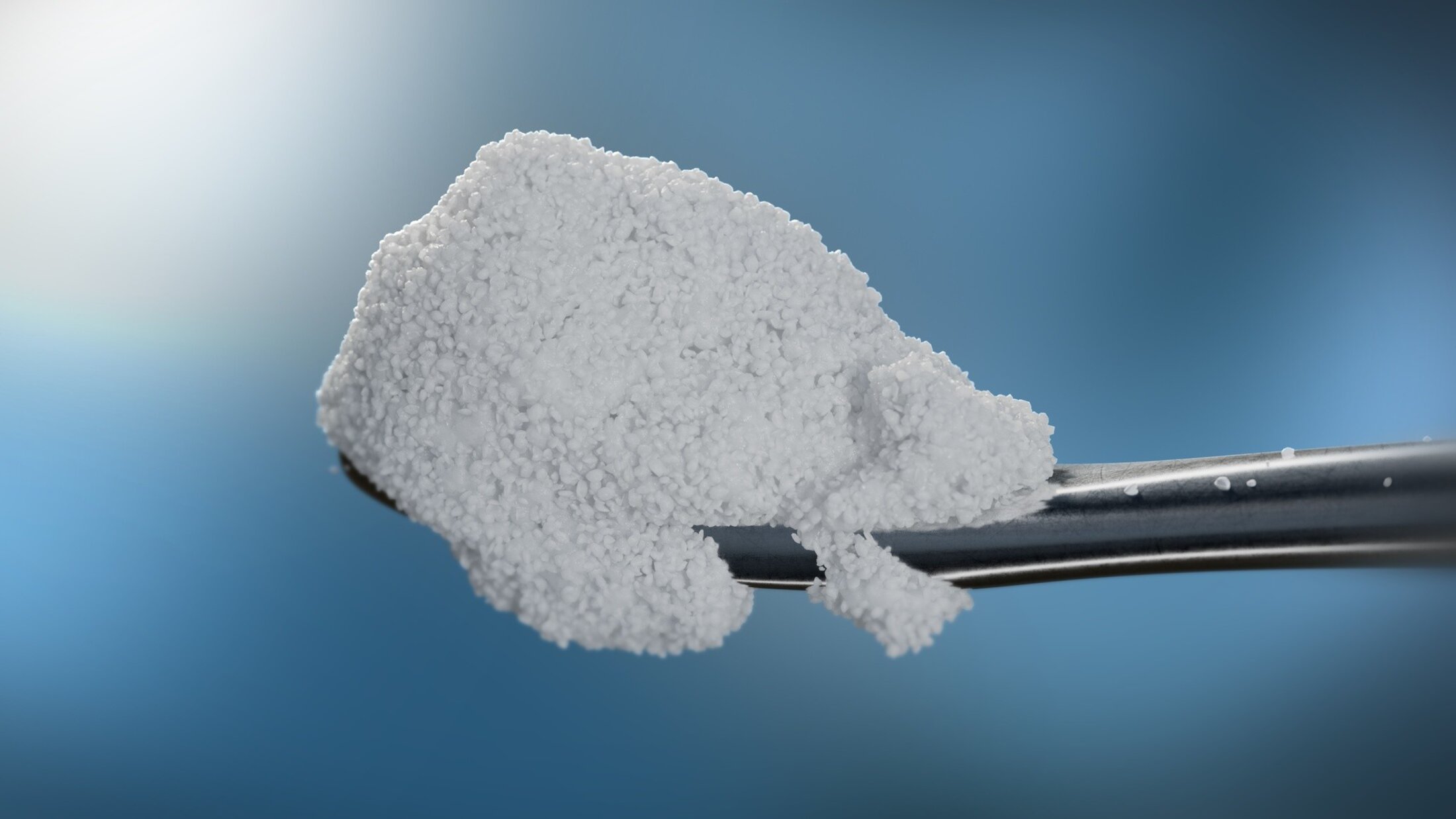 A metal devide holding what looks like a small, bumpy piece of white fabric. It's part of  Restrata, the wound care product.