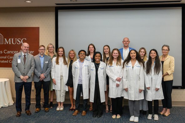 A group of students and faculty members stand together for a photo.