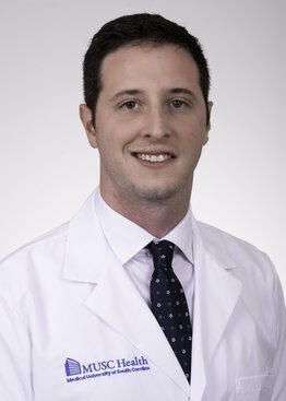 Ben Strickland, MD, Cancer - Brain & Spine Tumors, Neurosurgery, Spine Surgery wearing a white coat