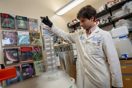 a researcher lifts samples out of a container of liquid nitrogen in a research lab