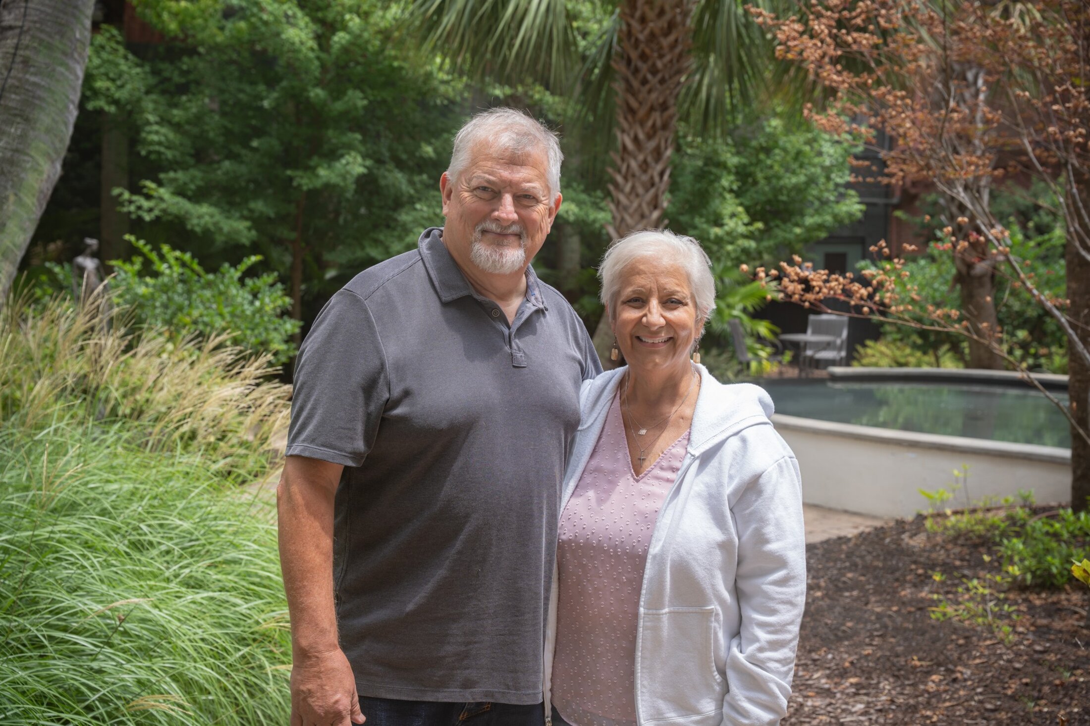 A couple pose in a garden setting.