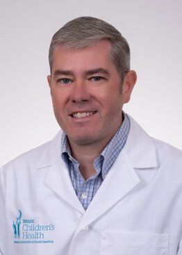 Brian Bridges Pediatrics wearing a white coat