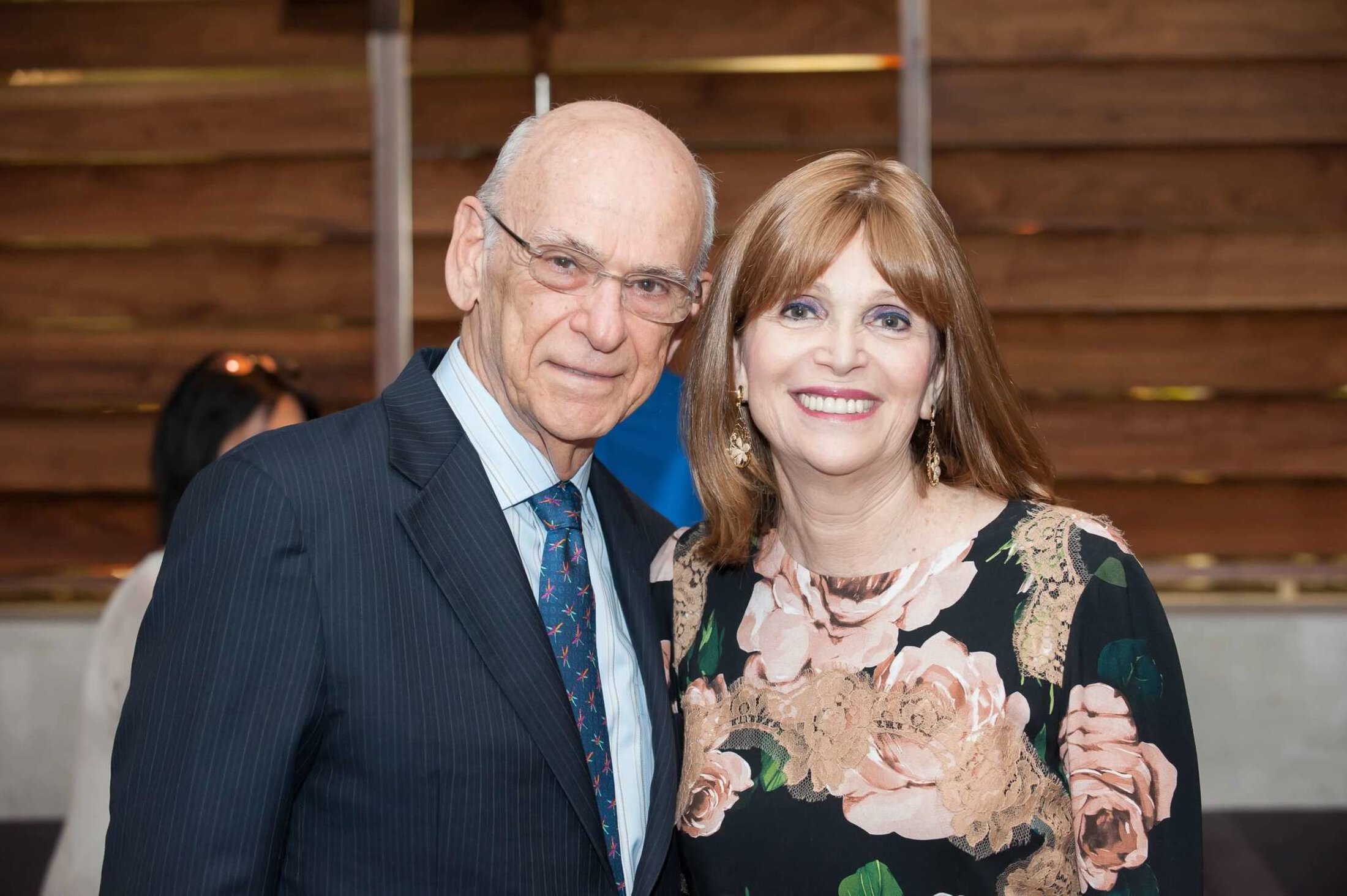 A couple pose for a photo at an event in formal attire.