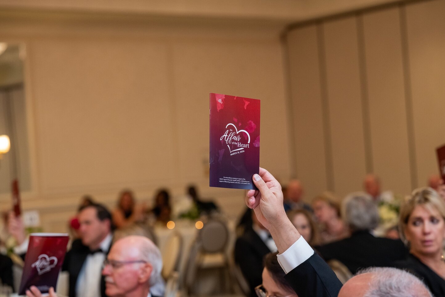 Attendee holding An Affair of the Heart event program in hand