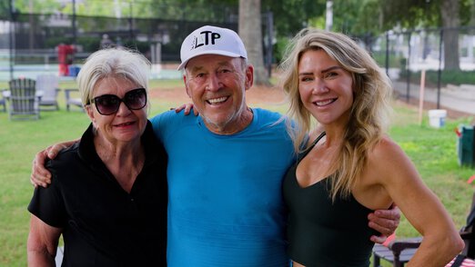 a smiling family photo at the pickleball court