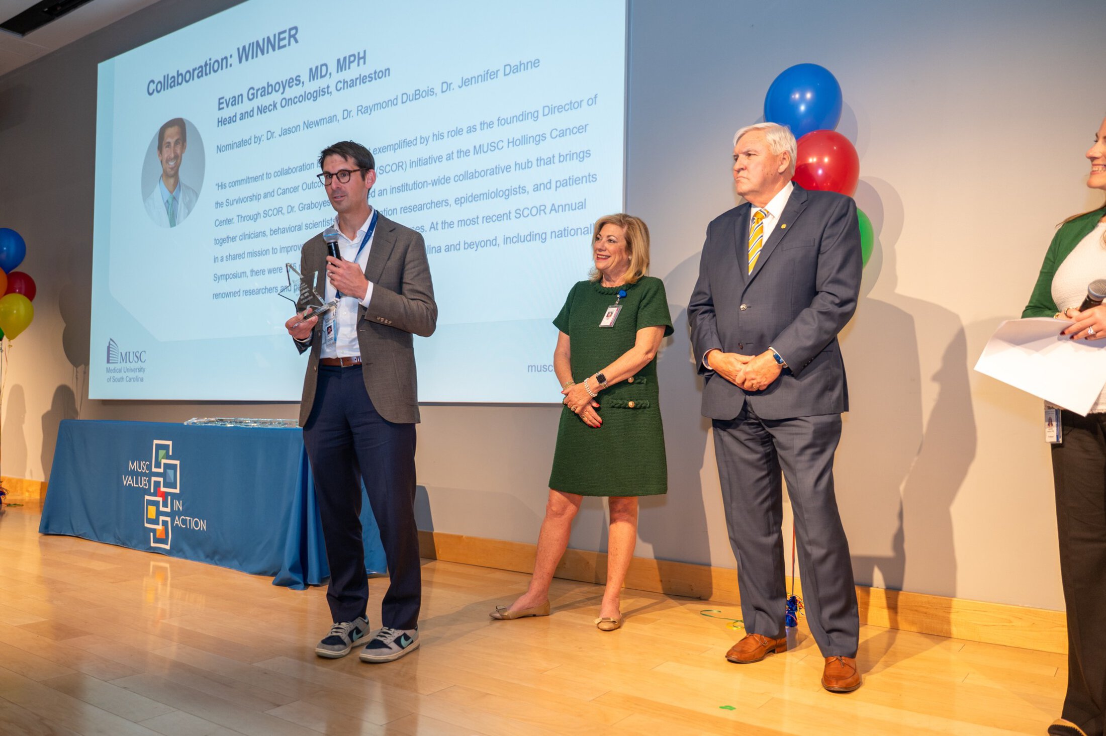 VIA Graboyes, Dr Cole and Mrs Cole standing on a stage speaking