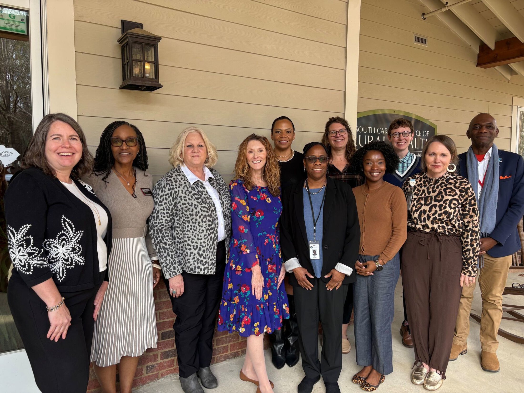 The South Carolina Clinical & Translational Research Institute's Community Engagement Program leadership team and Community Advisory Board members lined up for a group photo outside their meeting space at the South Carolina Office of Rural Health.