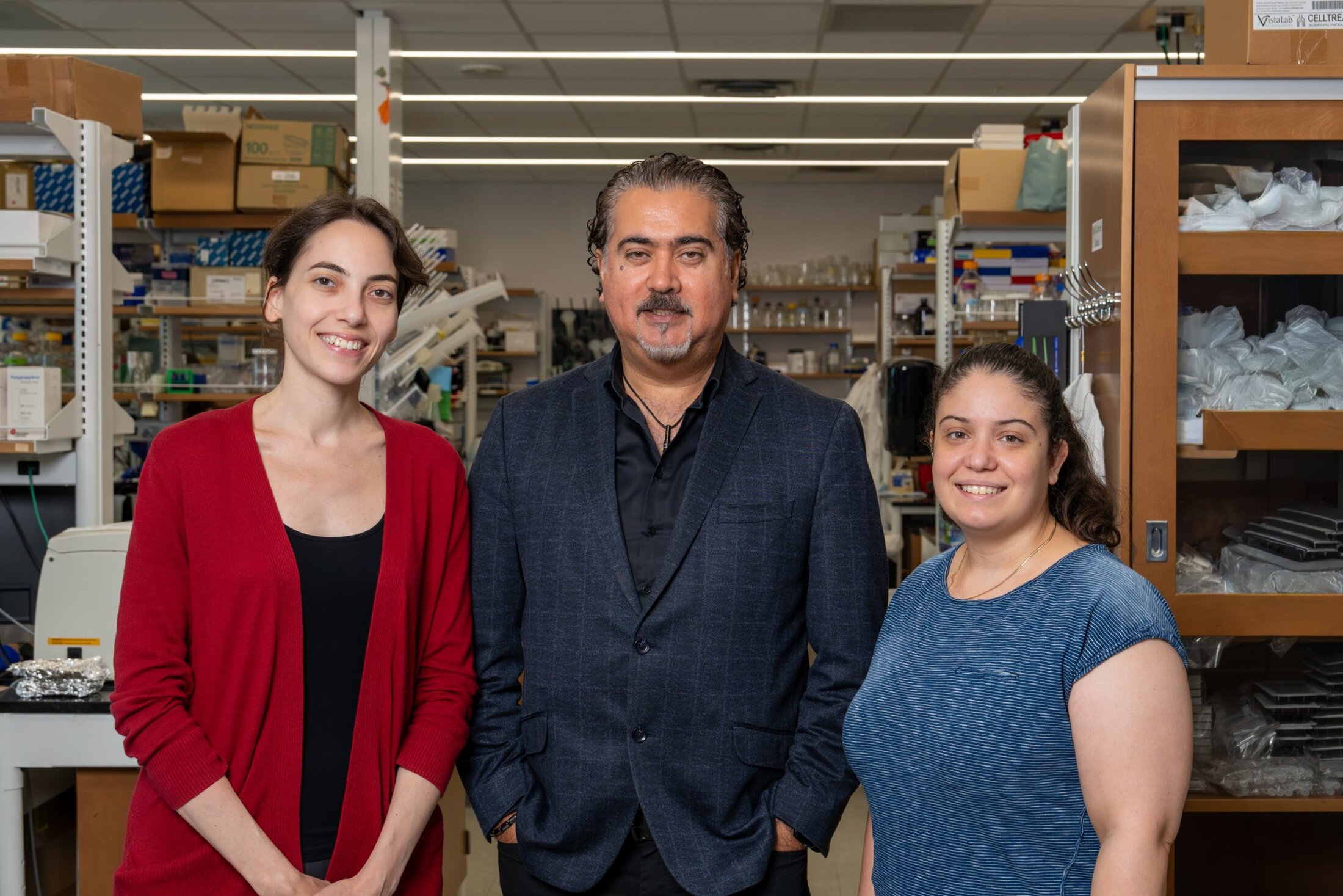 Three scientists pose in a cancer research lab.