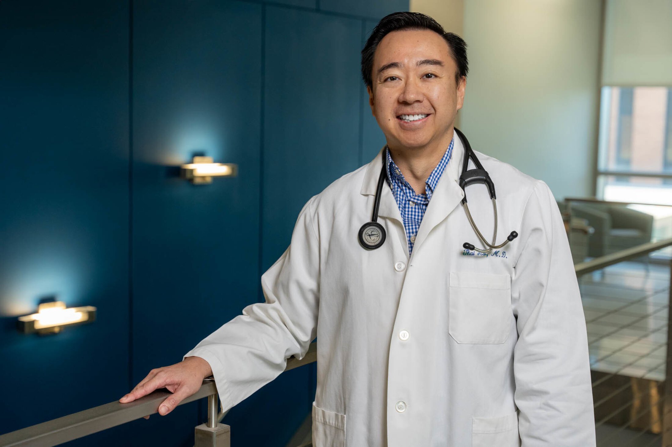 Dr. Thai Ho poses in his white coat and stethoscope.