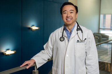 Dr. Thai Ho poses in his white coat and stethoscope.
