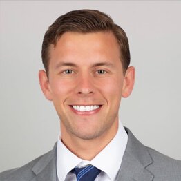 Jonathan Ferguson, wearing a grey suit with blue striped tie