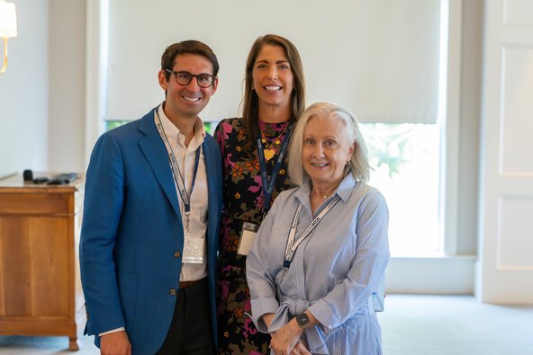Three people stand together for a photo.