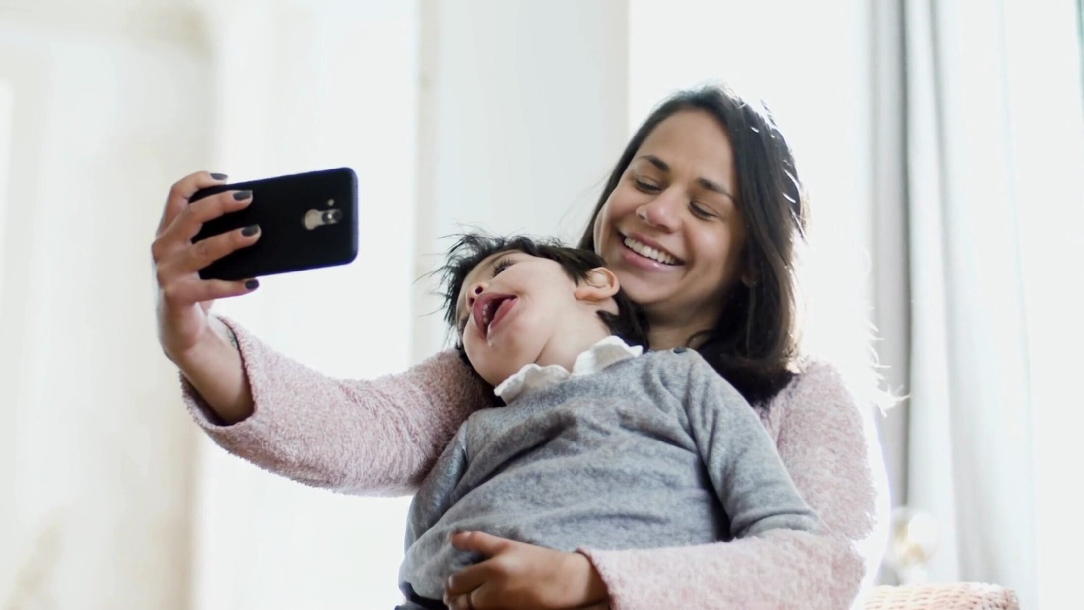 Woman taking a selfie with a baby on her lap